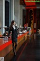 A woman standing in front of a bar in a restaurant.