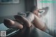 A woman laying on a couch with her feet up on a table.