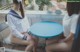 Two young women sitting at a blue table.