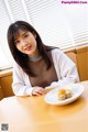 A woman sitting at a table with a plate of food.