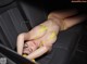 A woman in a yellow bikini laying in the back seat of a car.