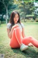 A woman sitting on the grass in a park.