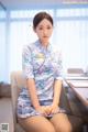 A woman sitting on a chair in an office.