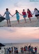 A group of young women holding hands on a beach.