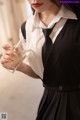 A woman in a black dress holding a glass of water.