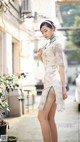 A woman in a blue and white dress is walking down the street.