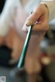 A woman is painting her nails with a brush.