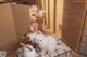 A little girl sitting on top of a bed next to two cats.