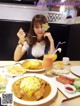 A woman sitting at a table with a plate of food.