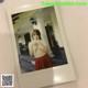 A polaroid photo of a woman in a red skirt.