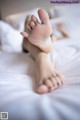 A woman laying on a bed with her feet up.