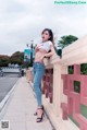 A woman in jeans and a white shirt posing on a bridge.