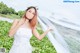 A woman in a white wedding dress posing for a picture.