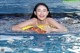 A woman in a swimming pool holding a life preserver.