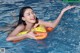 A woman floating in a swimming pool with an inflatable ring.