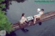 A couple of women sitting on top of a wooden bridge.