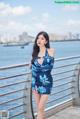 A woman in a blue dress standing on a pier.