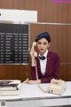 A woman sitting at a desk talking on a telephone.