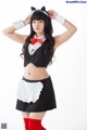 A woman dressed in a maid outfit posing for a picture.