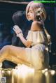 A woman in a white dress sitting on a table.